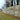 Picture of Sound Shield Pro acoustic reflective fence being erected along the side of a large lawn, showing the central mid-rail ready to be screwed into position.