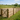 A sand school surrounded by sawn post & rail fencing, with a 5 bar gate in the foreground and a horse and rider in the distance. (AI-generated)